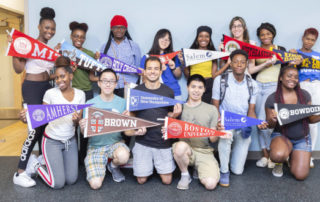 Students pose with their college banners.