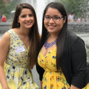 Andrea and Yessenia, smiling, in front of a fountain